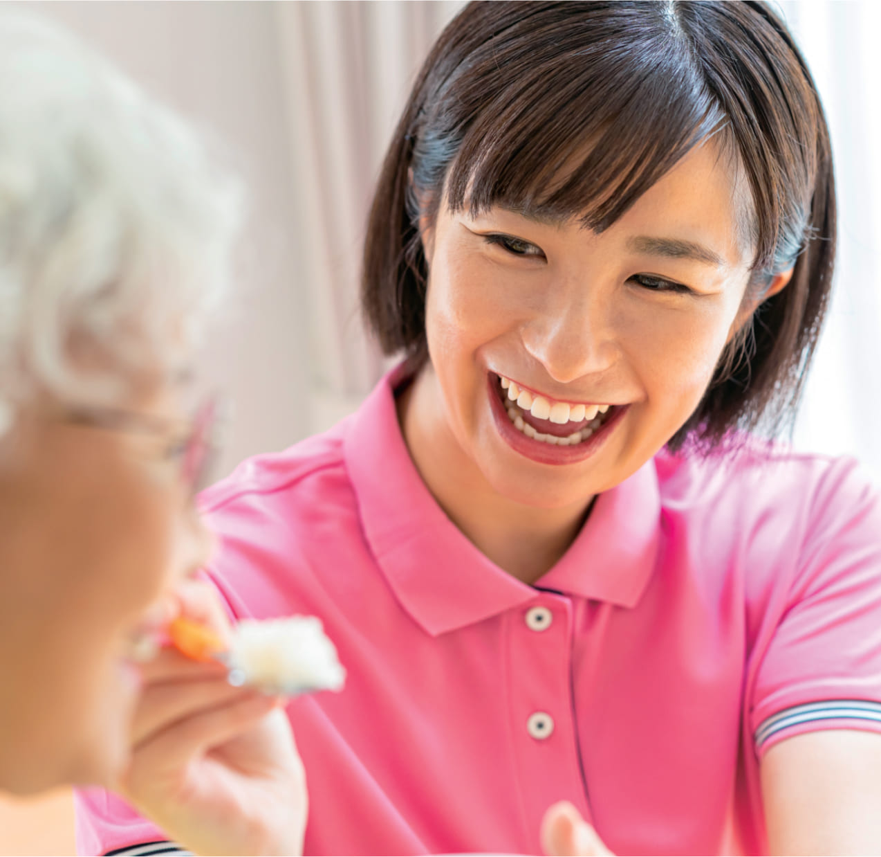 おばあさんにご飯をあげてる女性